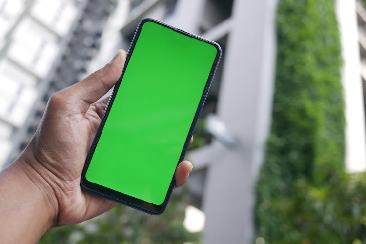 Man Hand Holding Cellphone With Mockup Screen