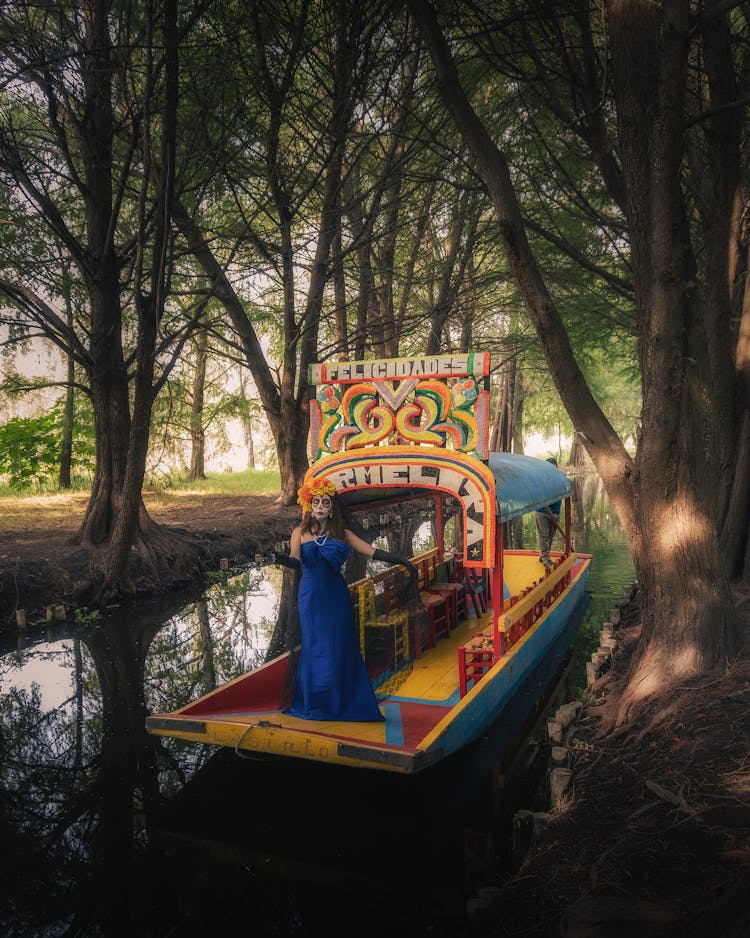 Woman Wearing A Festival Dress And Mask Standing On A Decorative Boat In A Park