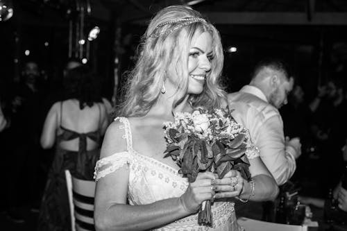 Grayscale Photo of Woman Holding Bouquet of Flowers