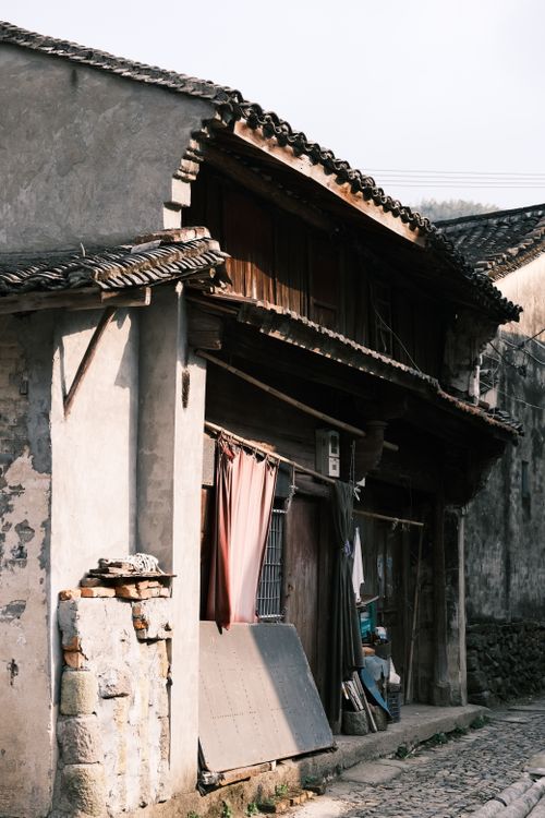 Free Old abandoned house with rustic charm in a quiet village street setting. Stock Photo