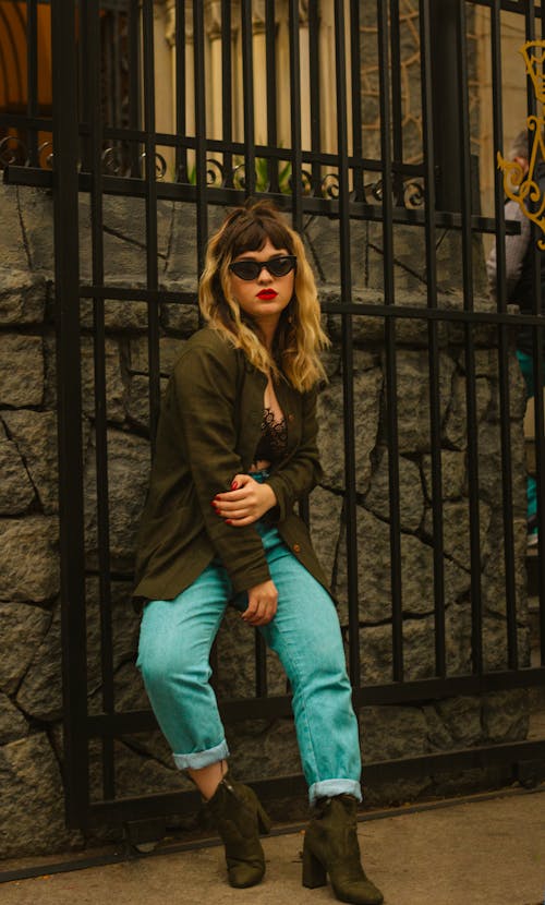 Young Fashionable Woman Posing on the Background of a Gate 