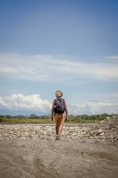 A lone backpacker ventures through a vast desert landscape in Granada, Meta, Colombia.
