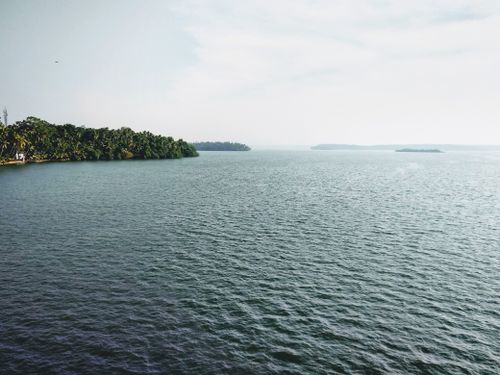 Free A peaceful view of an overcast seascape with lush greenery on islands. Stock Photo