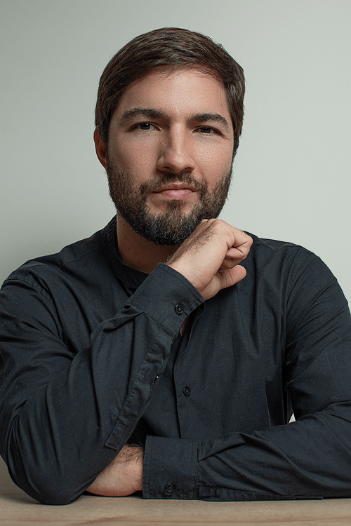 Free Close-up portrait of a bearded man in a black shirt against a neutral background. Stock Photo