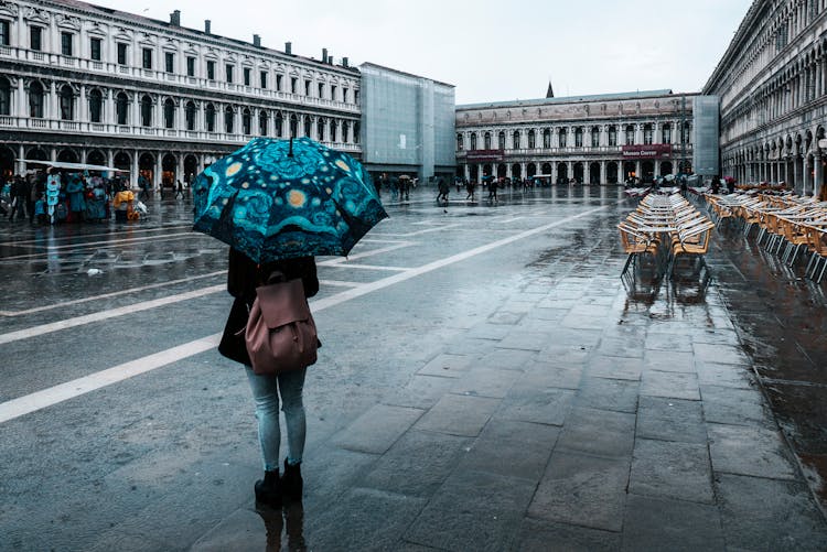 Backview Of Person Using An Umbrella On A Rainy Day 