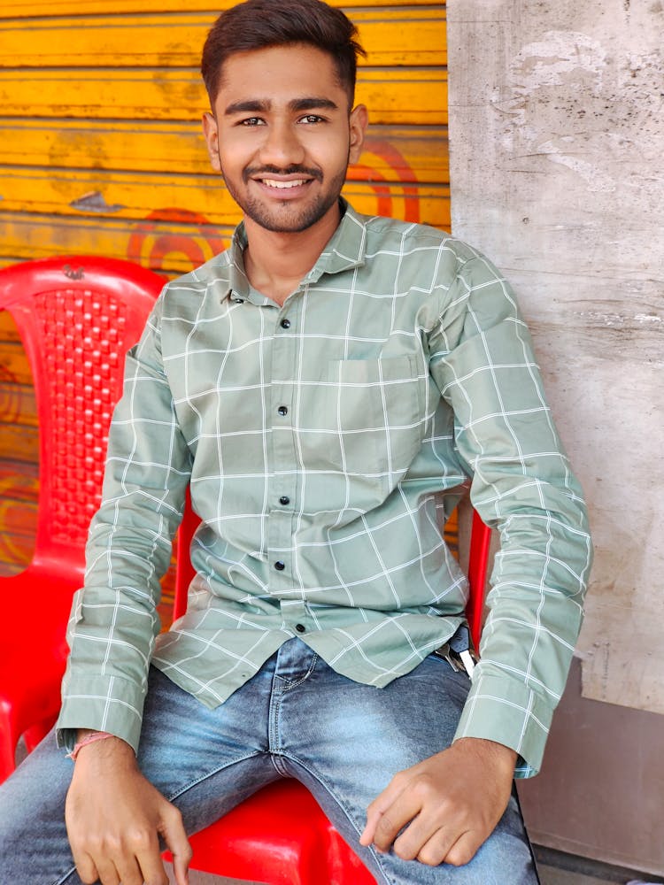 Man In Gray Plaid Long Sleeves Sitting On A Chair