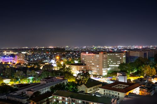 Free Aerial shot of a bustling cityscape at night with brightly lit buildings and urban sprawl. Stock Photo