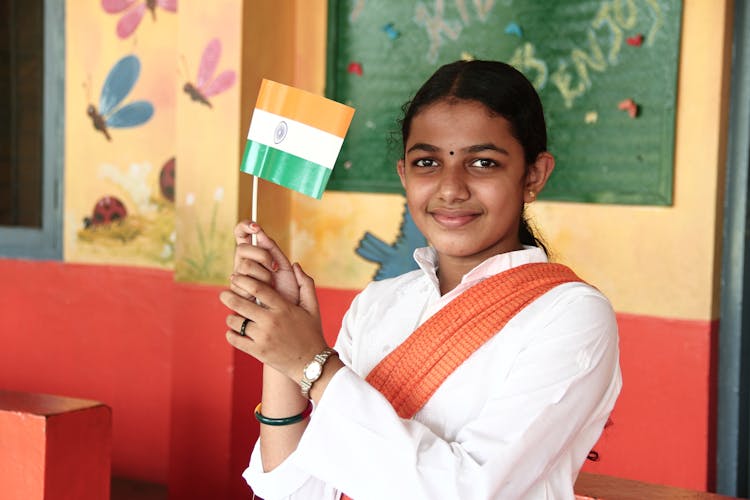 Smiling Cute Indian School Girl With Tricolour Flag