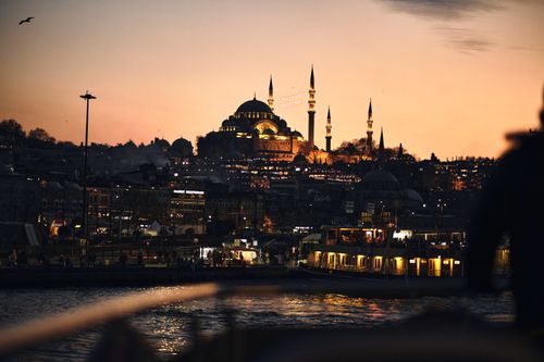 Free Suleymaniye Mosque silhouetted against a vibrant Istanbul sunset, reflecting on the Golden Horn. Stock Photo