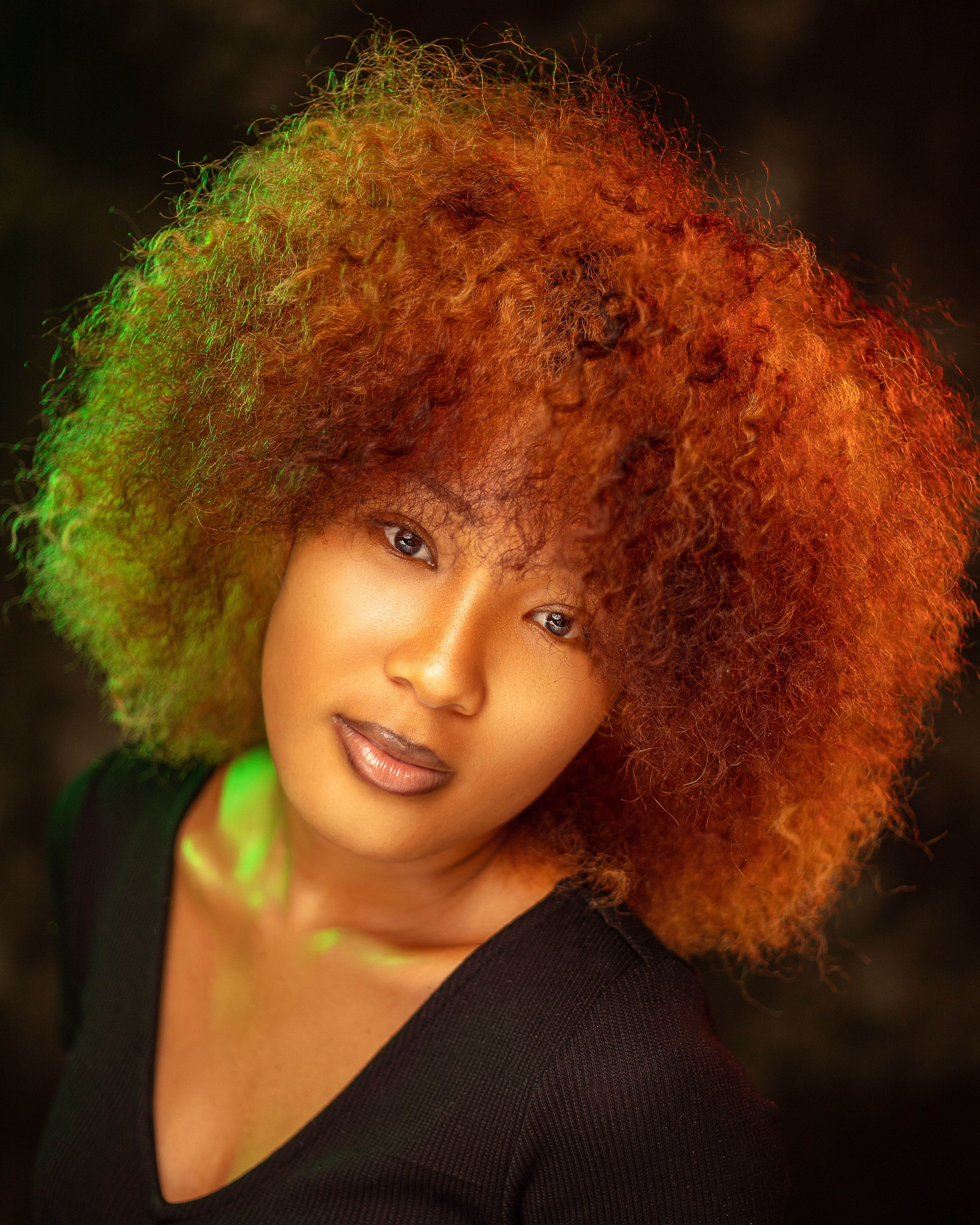 Close-up portrait of a woman with vibrant afro hair in Abidjan, Côte d'Ivoire.