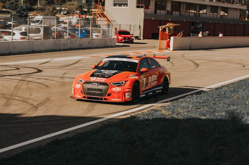 An Orang Audi RS 3 Racecar at a Racetrack