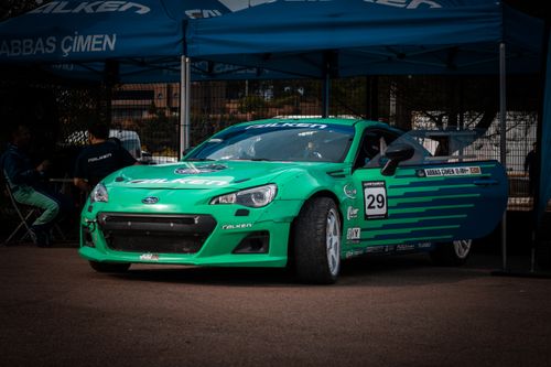 Free Dynamic shot of a green Subaru racing car parked in a motorsport event setting. Stock Photo