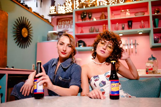 Two stylish women enjoying drinks in a vibrant, retro-styled diner setting.