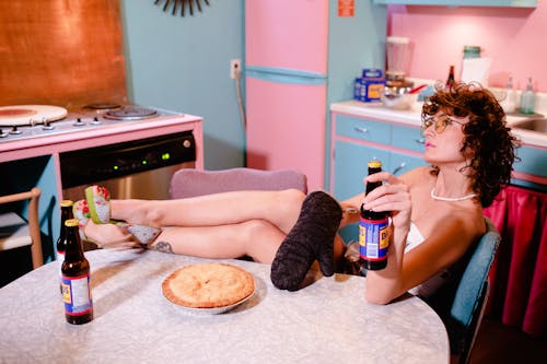 Woman with Bottle Sitting on Vintage Kitchen