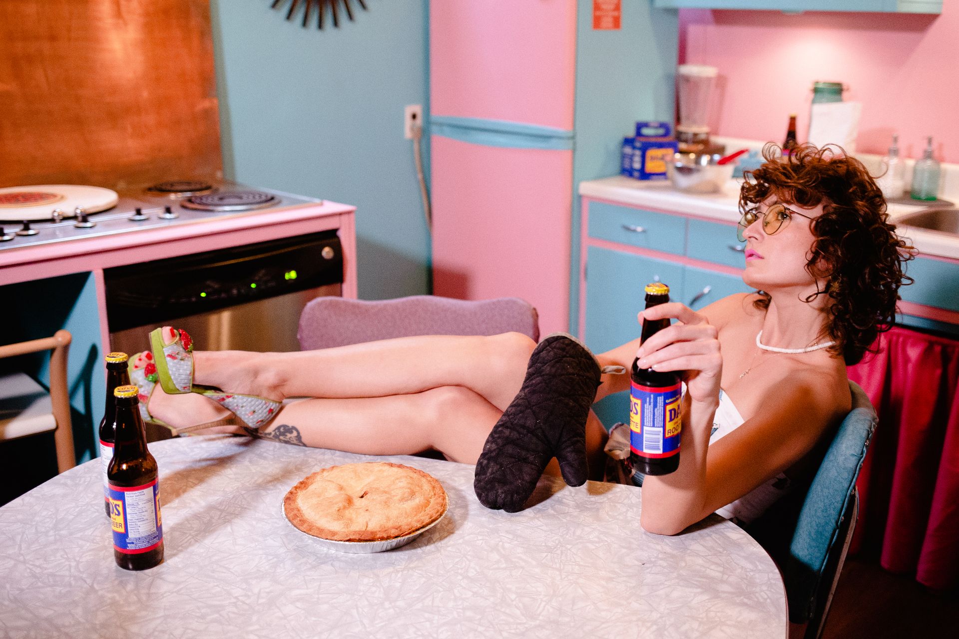 Woman with Bottle Sitting on Vintage Kitchen