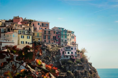 A Group of Colorful Houses on a Rock Mountain Under Blue Sky