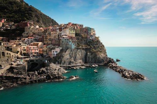 A Town in a Rock Mountain Near Bod of Water Under Blue Sky