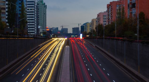 Captivating long exposure of light trails on a highway in Almaty, Kazakhstan at dusk.