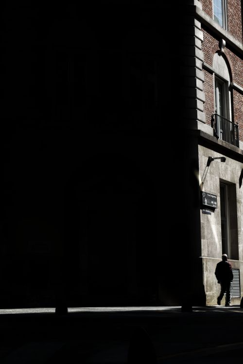 Free Silhouetted person walking along a shadowed street corner in Buenos Aires, Argentina. Stock Photo