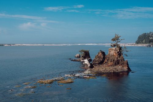 Free A beautiful ocean view with a scenic rock formation under a clear blue sky. Stock Photo