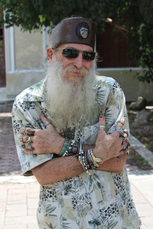 Free Elderly man with a long beard and multiple rings stands confidently outdoors. Stock Photo