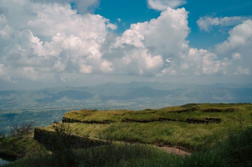 Free Scenic view of green terraces under a vibrant sky filled with white fluffy clouds. Stock Photo