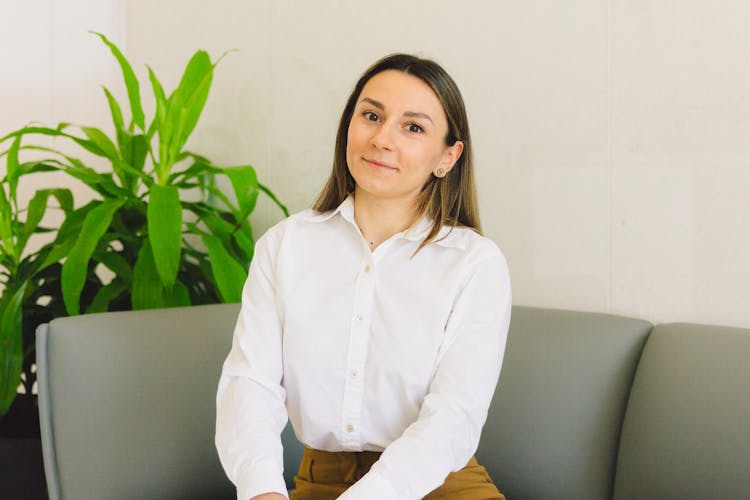 A Woman In White Long Sleeves Sitting On The Couch