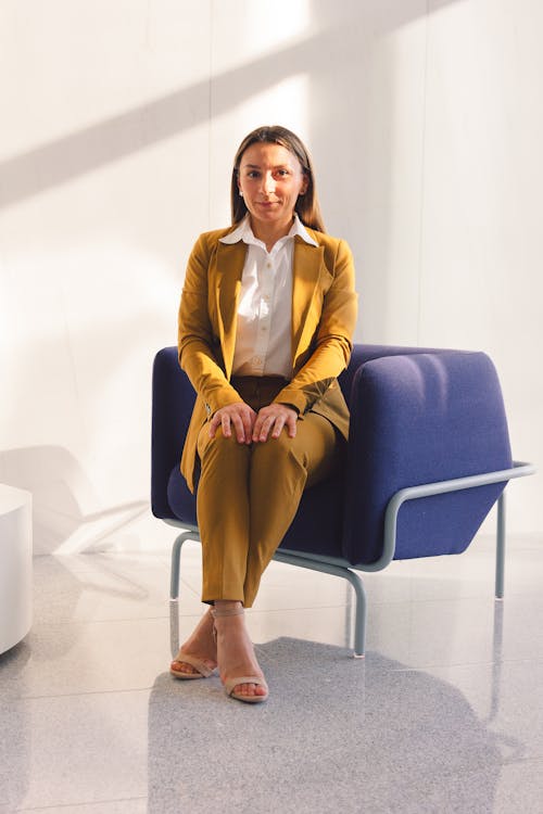 Free A Woman in Yellow Blazer Sitting on the Chair Stock Photo