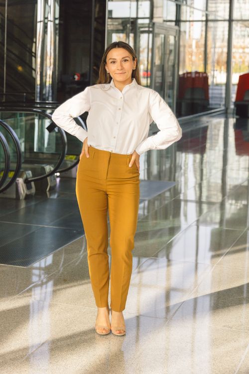 Free Professional portrait of a stylish woman in office attire standing confidently indoors. Stock Photo