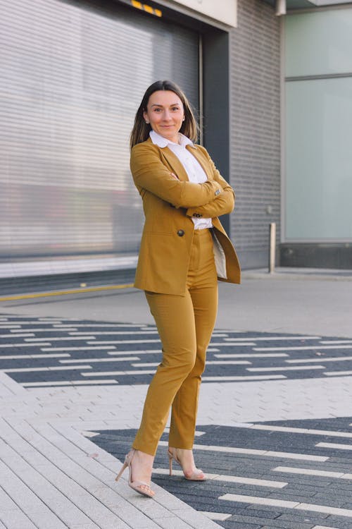 Woman in Brown Coat and Brown Pants Standing on the Street