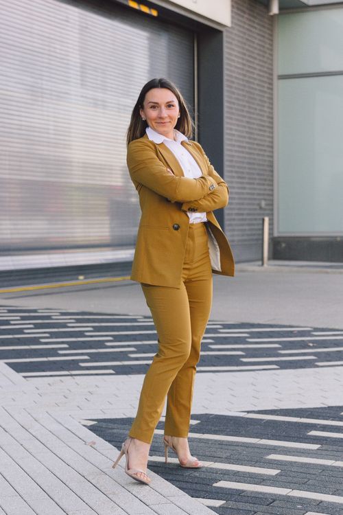 Free Confident woman in brown suit standing with crossed arms in an urban setting. Stock Photo