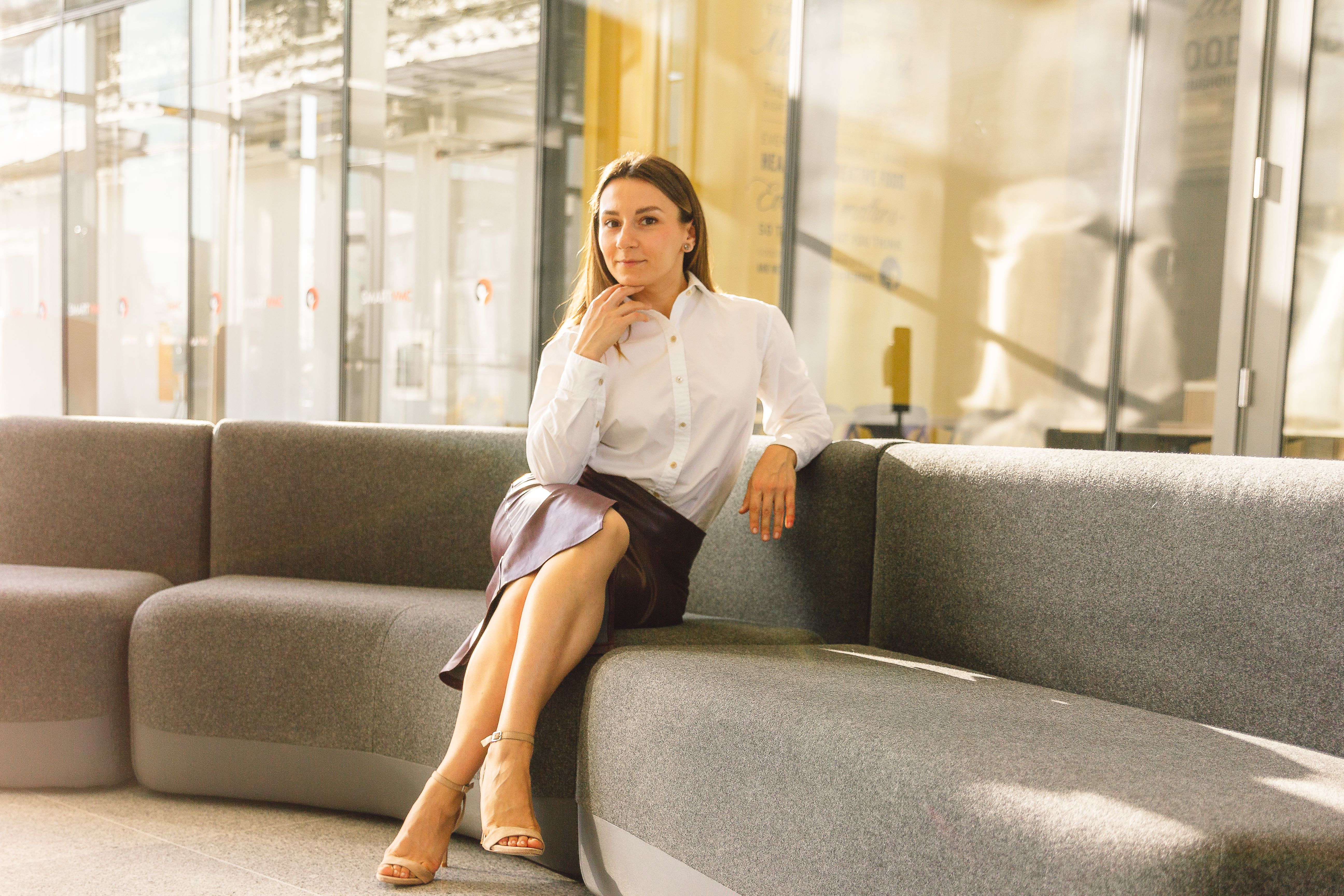 A Woman in White Long Sleeves and Leather Skirt Sitting on the Couch ...