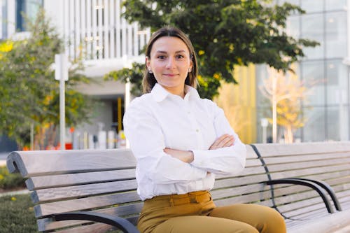 Woman in White Dress Shirt sitting on a Bench