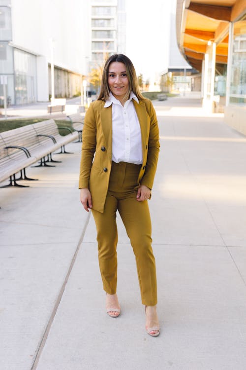 Woman in Olive Green Blazer and Pants Standing on Sidewalk