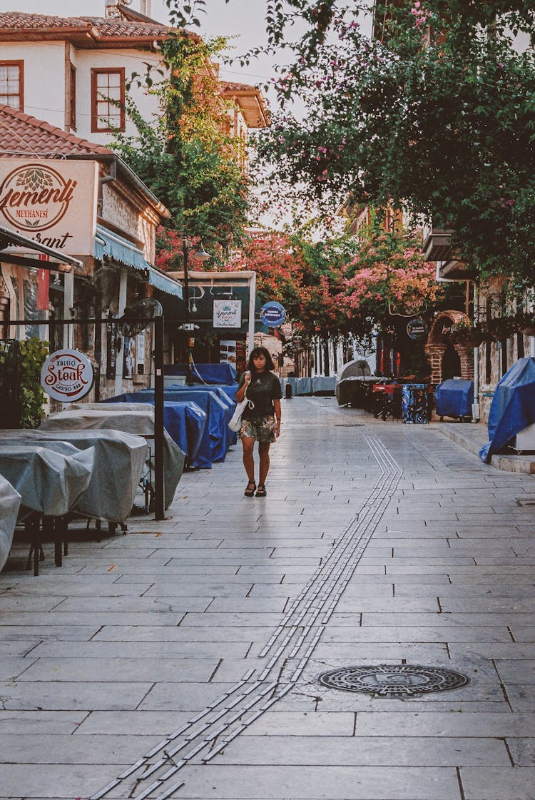 Woman In Black Top Walking On The Street