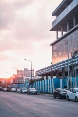 Pune street at sunset with parked cars and buildings under construction