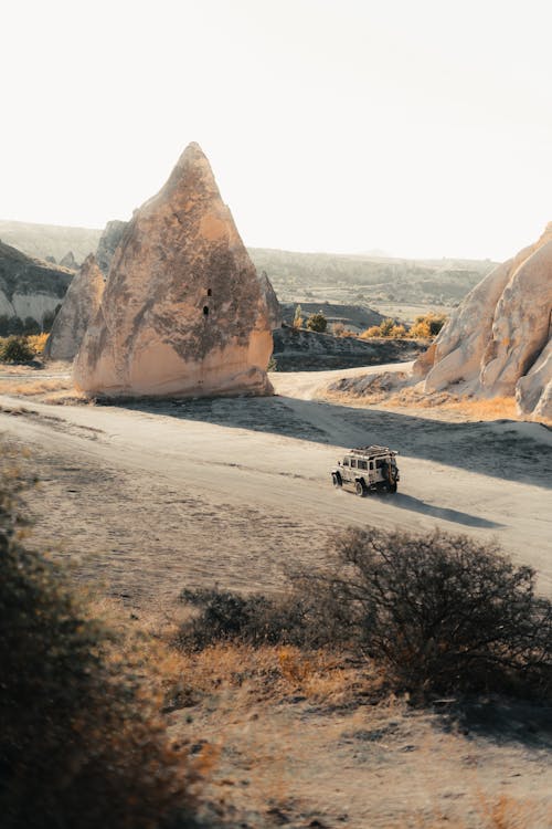 Car on Dirt Road among Rock Formations
