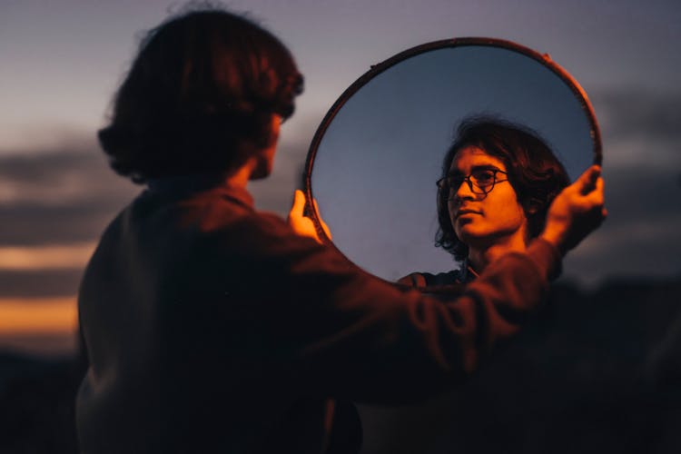 A Man Holding A Mirror 