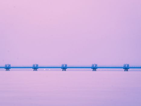 Blue Bridge across River under Pink Sky