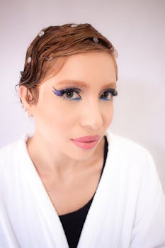 Close-up portrait of a woman with artistic eye makeup and short hair.