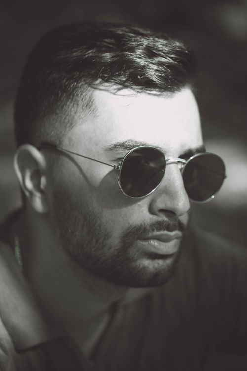 Free Black and white portrait of a man wearing sunglasses, displaying modern style. Stock Photo