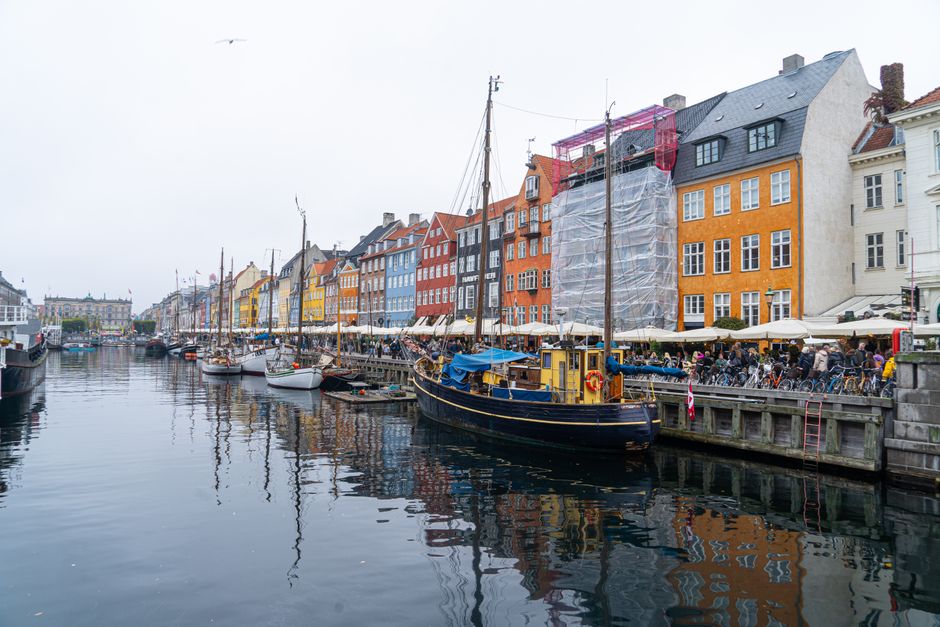 Colorful buildings and boats at Nyhavn canal in Copenhagen, showcasing vibrant city life.