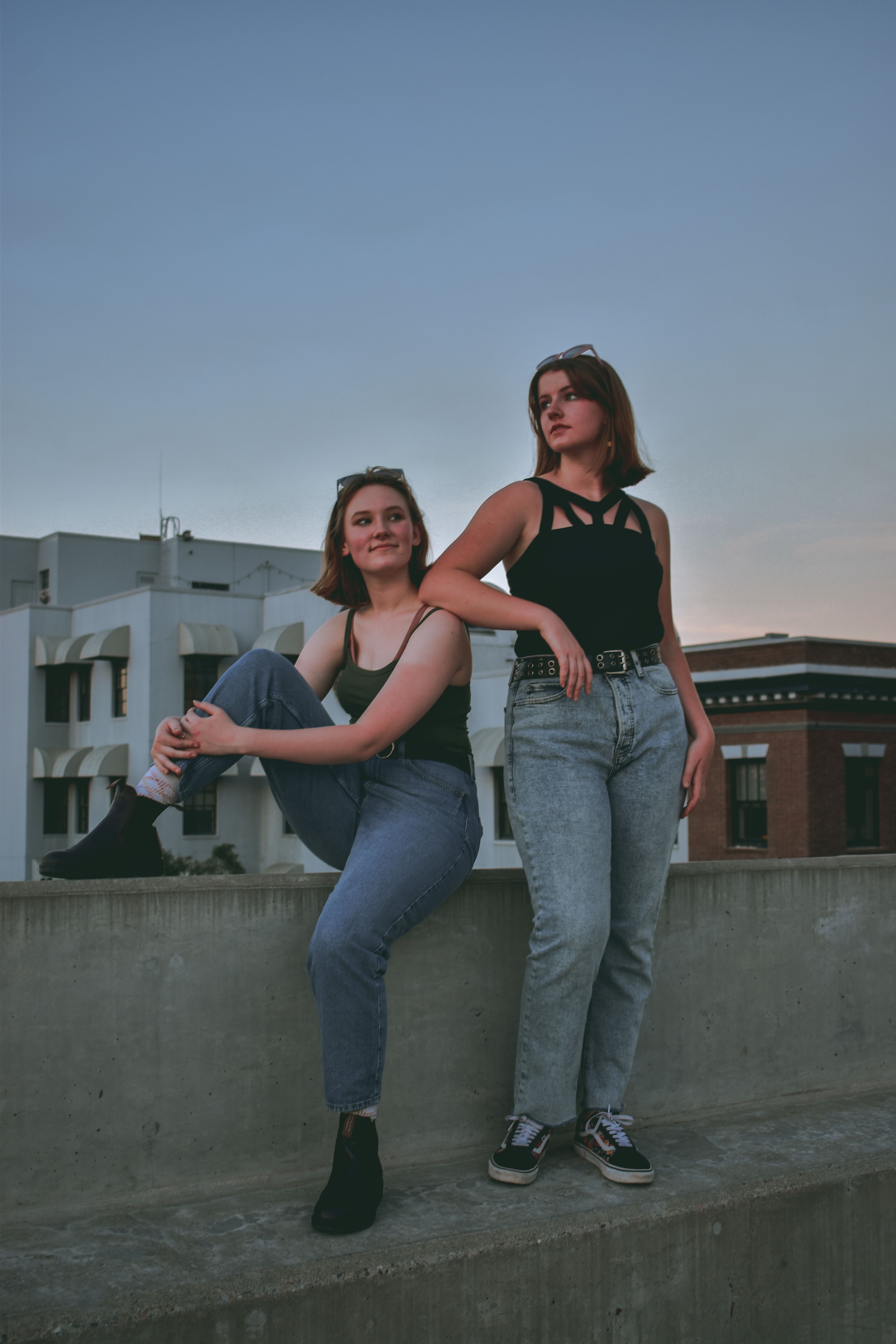 Stylish urban portrait of two women posing on a rooftop at twilight in Modesto, CA.