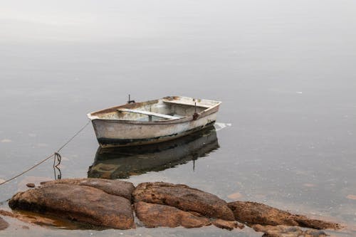 A Boat on Water Near the Rock