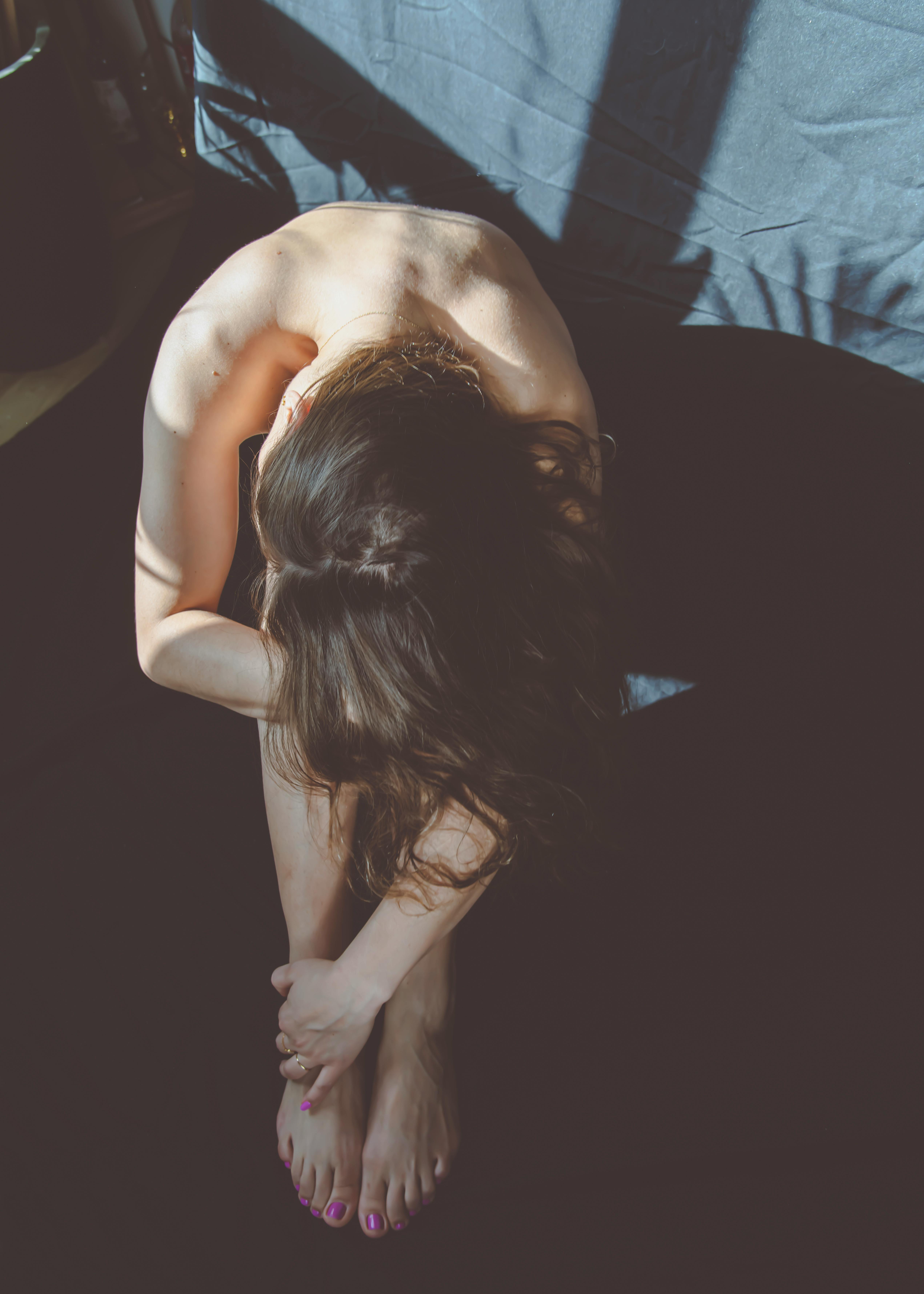 photograph of a shirtless woman sitting