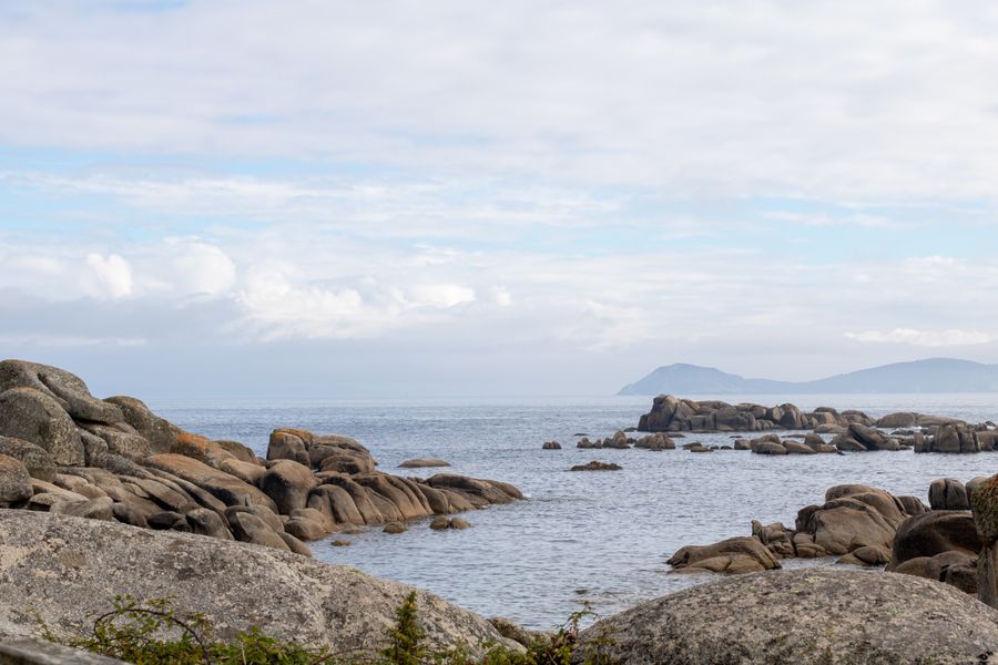 Peaceful coastal view of rocky shores in El Grove, Spain.