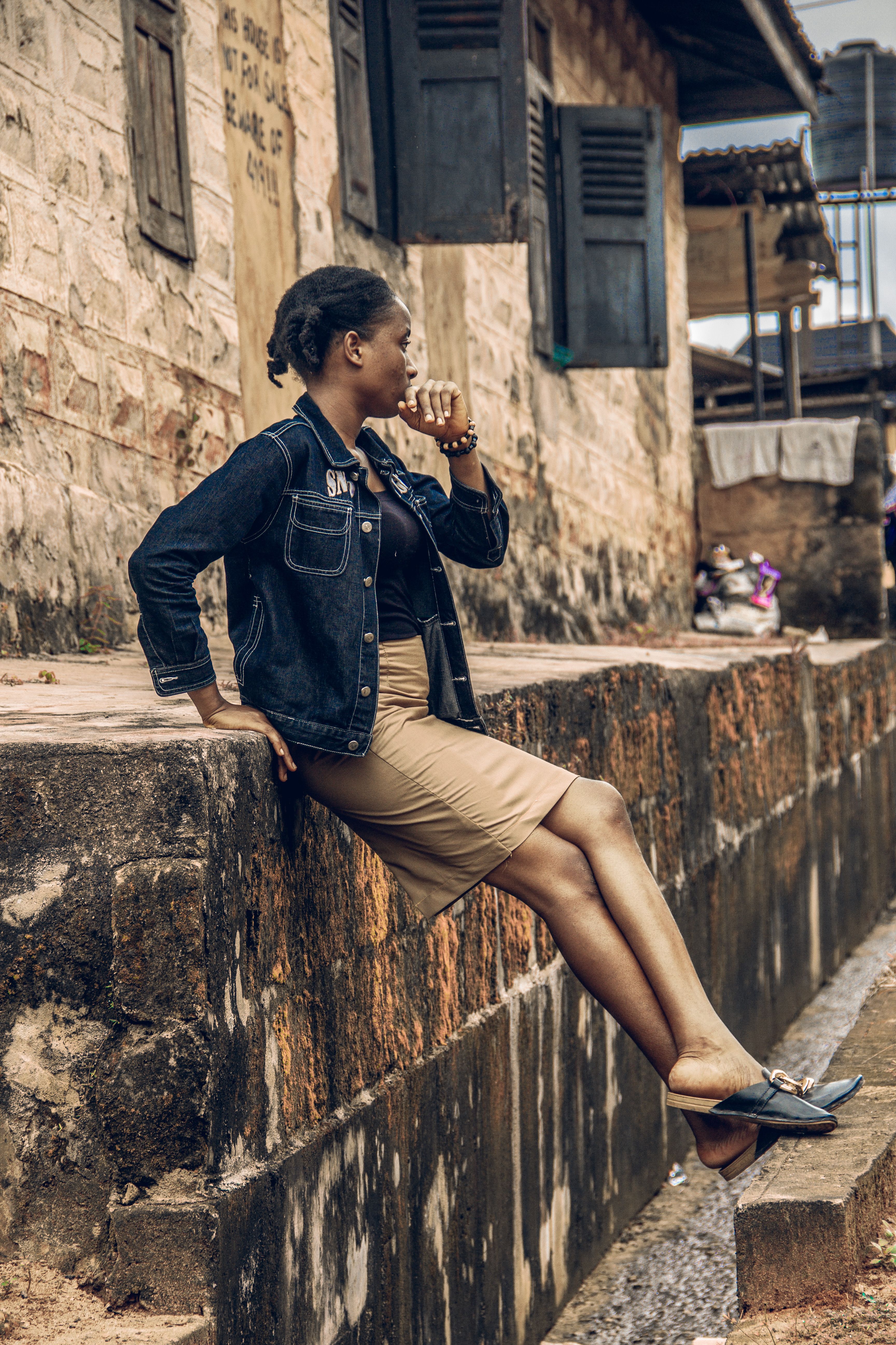 A Woman in Black Jacket and Brown Skirt Sitting on the Street · Free ...