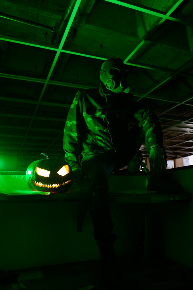 Person In Mask And With Halloween Pumpkin