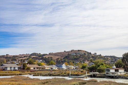 Landscape of Houses by the River and Hills in Distance 