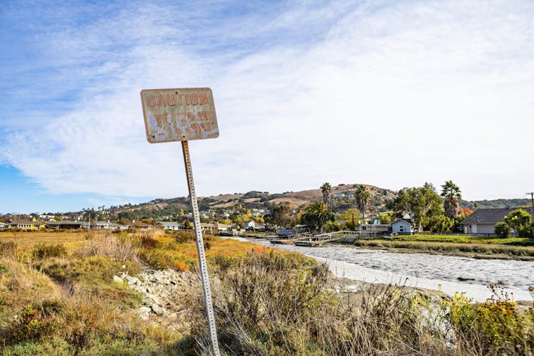 Damaged Caution Sign Near A River